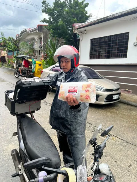 Daytime parcel handover to a delivery rider